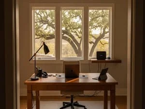 Home office desk with computer networking setup, wooden furniture, and organized cable management